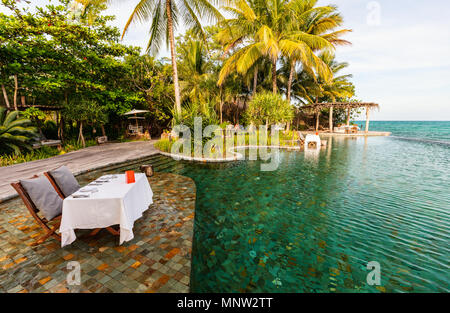 Romantica cena di lusso vicino piscina infinity a resort tropicale sulla sunset Foto Stock