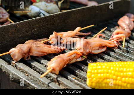 Calamari fritti sono su un grill barbecue durante la fiera di strada. Close-up. Foto Stock