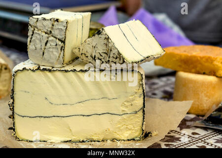 Intero e dentellata capi di diversi tipi di formaggio sul contatore di mercato. Hard e soft la produzione del formaggio. Close-up. Foto Stock