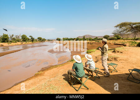 La famiglia di madre e bambini su safari Africano vacanze godendo di Ewaso Nyiro viste in Samburu Kenya Foto Stock