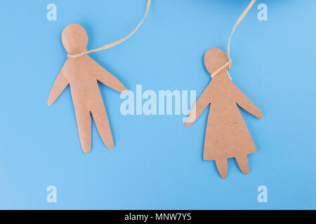 Appendere sé stesso concetto di persona della carta su sfondo blu Foto Stock