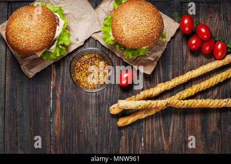 Freschi Fatti in casa hamburger e grissini su sfondo di legno. Foto Stock
