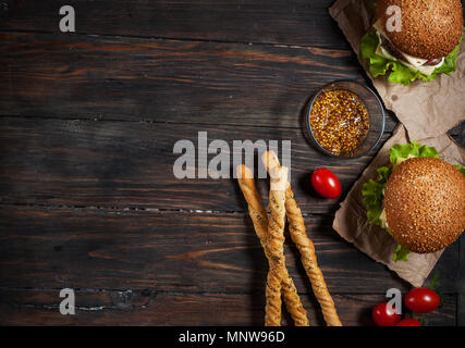 Freschi Fatti in casa hamburger e grissini su sfondo di legno. Foto Stock