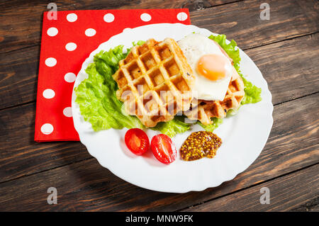 I waffle belgi con uovo e salmone su tavola di legno. Foto Stock