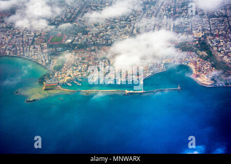 Vista aerea attraverso la finestra di un aereo della bellissima città di Chania con il vecchio porto e il famoso faro, Creta, Grecia. Foto Stock