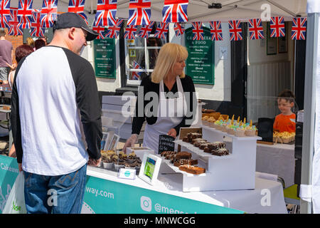 Ringwood, New Forest, Hampshire, Inghilterra, Regno Unito, 19 maggio 2018. Non tutti hanno voluto guardare il royal wedding del principe Harry e Meghan Markle. Alcuni avevano altre distrazioni come questo ragazzo occhiatura fino alcuni dolci presso un mercato in stallo. Foto Stock