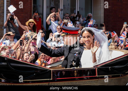 Windsor, Regno Unito, 19 maggio 2018. Royal Wedding. Il principe Harry sposa Meghan Markle. In seguito il loro matrimonio presso la Cappella di St Georges nel parco del Castello di Windsor, il nuovo titolo S.A.R. il principe Harry, duca di Sussex e Meghan, duchessa di Sussex onda per la folla durante una processione attraverso Windsor in Ascot Landau carrello. 19 Maggio, 2018. Windsor, in Inghilterra. Credito: amanda rose/Alamy Live News Foto Stock