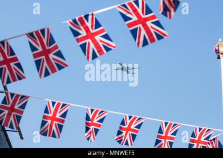 Windsor, Regno Unito. 19 Maggio, 2018. Un aereo dall'aeroporto di Heathrow vola sopra bunting appeso in un centro storico street il giorno delle nozze di alla cappella di San Giorgio nel Castello di Windsor del principe Harry e Meghan Markle, ora il Duca e la Duchessa di Sussex. Credito: Mark Kerrison/Alamy Live News Foto Stock