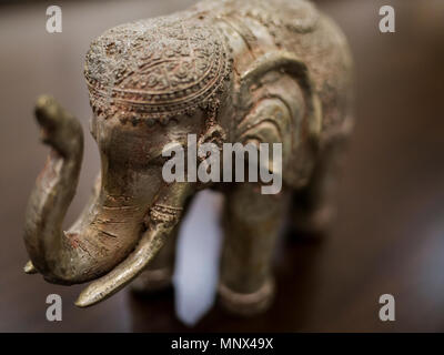 Close up ancora in vita di intagliato elefante in metallo con sfondo di legno Foto Stock