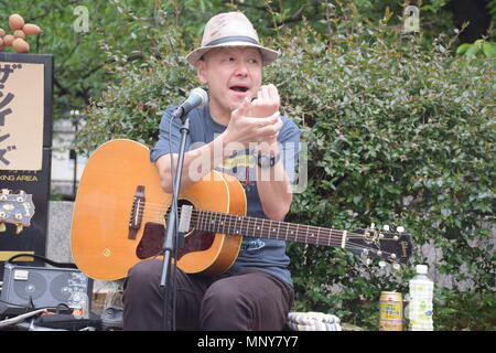 Il giapponese l'uomo con il cappello a suonare la chitarra e canta sulla strada a Kyoto, Giappone Foto Stock