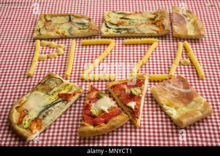 Pezzi di pizza intorno a una scritta fatta con grani di pasta grezza Foto Stock