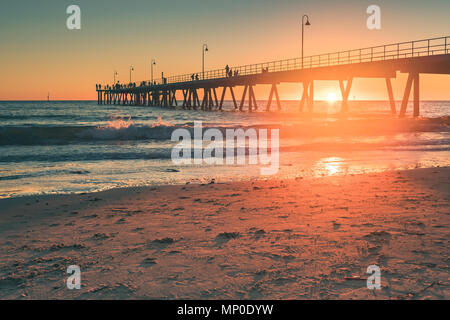 Spiaggia di Glenelg con jetty su sfondo al tramonto, Sud Australia Foto Stock