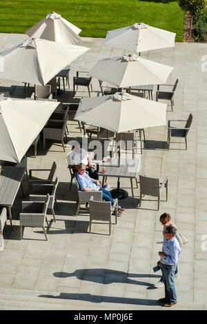 Gli ospiti di un hotel di lusso seduto su una terrazza soleggiata Foto Stock