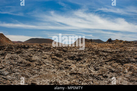 Vista panoramica di un cratere vulcanico nel Parco Nazionale di Timanfaya sotto un cielo blu con nuvole. Lanzarote, Isole Canarie, Spagna. Foto Stock