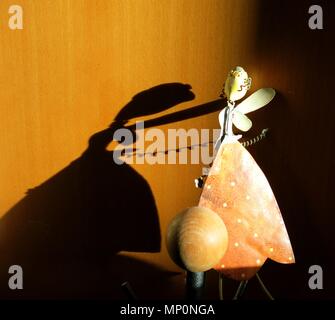 Fata figura gettando la sua ombra su armadio di legno. Concetto : luce e ombra nel minimalismo. Foto Stock