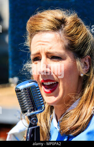 Saluto alla 40s popolare evento nostalgico in Inghilterra. Cantante donna dalla vittoria di banda di guerra a cantare nel microfono, sul ponte di P22 a sandwich. Foto Stock