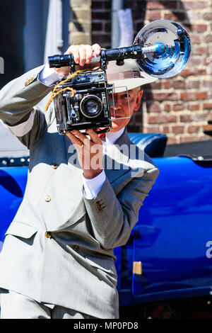 Saluto alla 40s evento a sandwich nel Kent. Reenactor uomo vestito come giornalista foto con velocità Graflex graphic fotocamera, scattare una foto del visualizzatore. Foto Stock