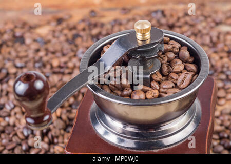 Close up retrò vecchio macinino da caffè con caffè torrefatto in grani. Close up, il fuoco selettivo Foto Stock