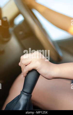 Mano di donna di toccare la trasmissione di cambio marcia dei SUV selezionare auto focus leggera profondità di campo con effetto sunray elaborati Foto Stock