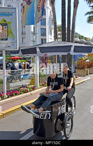 Cannes, Francia - 11 Maggio 2018: donna non identificato la distribuzione di diverse riviste per la folla e uno di ottenere una corsa, in corrispondenza della settantunesima Cannes Film Festiv Foto Stock