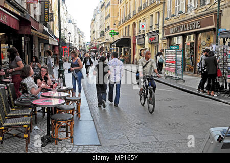 Persone che passeggiano e uomini in bicicletta lungo Rue Montorgueil Street vicino al quartiere Les Halles nel centro di Parigi Francia Europa KATHY DEWITT Foto Stock