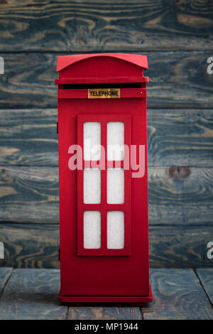 Confezione decorativa come classico Britannico rosso phone booth su blu Foto Stock