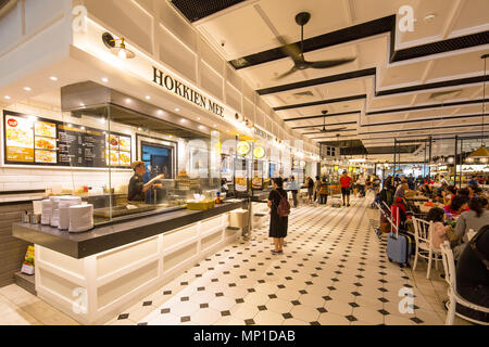 Una signora in abito nero controlla il menu' all'interno di un'area ristoro al terminal 4 dell'Aeroporto di Singapore. Il miglior aeroporto del mondo. Foto Stock
