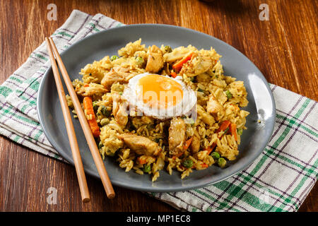 Riso fritto il Nasi goreng con uovo di pollo e le verdure su una piastra. Cucina Indonesiana. Foto Stock