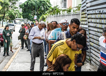 Caracas, Venezuela. Il 20 maggio 2018. Gli elettori si vede il rivestimento fino a essere registrati a votare nelle elezioni. Le elezioni presidenziali chiamato dall'Assemblea Nazionale Costituente sono stati effettuati con calma in Venezuela. Poche persone hanno partecipato e punti di governo sono stati visti, chiamato puntini rossi, nella periferia di centri di polling che ha chiesto al governo di assistenza sociale documento di identificazione noto come "carnet de la patria di un paese (scheda) dove dovrebbero indicare che essi avevano già votato per Maduro. Credito: SOPA Immagini limitata/Alamy Live News Foto Stock