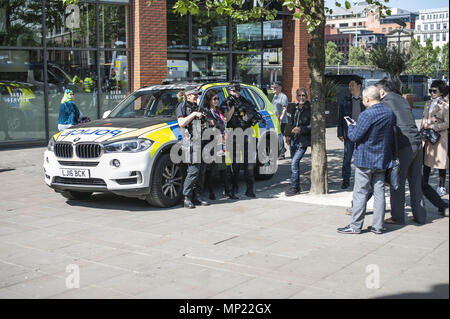 Manchester, Greater Manchester, UK. 19 Maggio, 2018. I turisti pongono per le immagini sui Piccadilly Gardens nel Manchester con poliziotti armati davanti al rally FLA e UAF rally e marzo. Uniti contro il razzismo protesta contro la Football Lads associazione al Rally di Castlefield Arena di Manchester a quasi un anno dopo il Manchester Arena bomba. Credito: Steven velocità SOPA/images/ZUMA filo/Alamy Live News Foto Stock