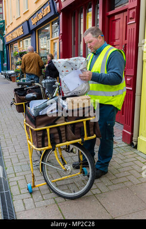 Irish Post Office, un post, portalettere con lettere e pacchi che porta bicicletta, Cahersiveen, nella contea di Kerry, Irlanda Foto Stock