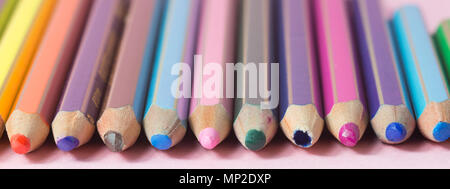 Molto usato matite di colori diversi isolati su uno sfondo di colore rosa. Concetto di ricambio per acquistare di nuove Foto Stock