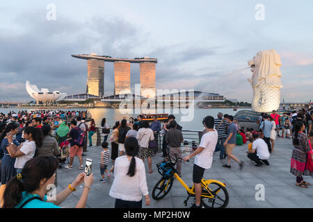 Singapore - 13 Maggio 2018: una grande folla di turisti scattare foto e selfie davanti alla fontana di Merlion dalla baia di Marina al tramonto in Singapore Foto Stock
