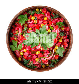 Vinaigrette a base di insalata di verdure bollite, cetrioli sottaceto, crauti confetture e conserve di piselli verdi in un vaso di argilla isolato su bianco. Tradizionale russo sn Foto Stock