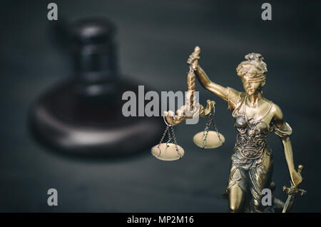 Il diritto e la giustizia, il concetto di legalità, bilancia della giustizia, giudice martello, Lady giustizia su un nero lo sfondo di legno. Foto Stock
