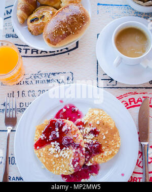 Prima colazione inclusa classic pancake con confettura di lamponi, caffè con latte, frutta e dolci. Buona mattina. Vista dall'alto. Foto Stock