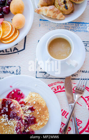 Prima colazione inclusa classic pancake con confettura di lamponi, caffè con latte, frutta e dolci. Buona mattina. Vista dall'alto. Foto Stock