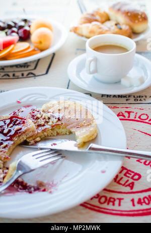 Prima colazione inclusa classic pancake con confettura di lamponi, caffè con latte, frutta e dolci. Buona mattina. Messa a fuoco selettiva. Foto Stock