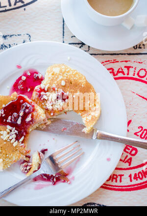 Prima colazione inclusa classic pancake con confettura di lamponi e caffè con latte. Buona mattina. Vista dall'alto. Foto Stock