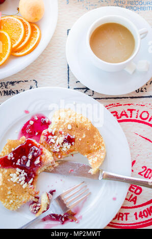 Prima colazione inclusa classic pancake con confettura di lamponi, caffè con latte e frutta. Buona mattina. Vista dall'alto. Foto Stock
