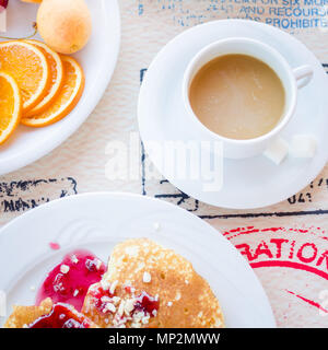 Prima colazione inclusa classic pancake con confettura di lamponi e frutta e caffè con latte. Buona mattina. Vista dall'alto. Square. Foto Stock