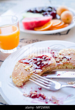 Prima colazione inclusa classic pancake con confettura di lamponi, succo d'arancia e frutti. Buona mattina. Messa a fuoco selettiva. Foto Stock