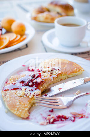 Prima colazione inclusa classic pancake con confettura di lamponi, caffè con latte, frutta e dolci. Buona mattina. Messa a fuoco selettiva. Foto Stock