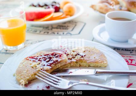Prima colazione inclusa classic pancake con confettura di lamponi, caffè con latte, frutta e dolci. Buona mattina. Messa a fuoco selettiva. Foto Stock