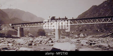 . Inglese: l'immagine mostra la inferiore originale ponte sul Ticino sul sud della rampa di accesso alla ferrovia del Gottardo Tunnel con Giornico in background e una locomotiva a vapore con due pianali atti a passare il ponte. La foto è stata scattata prima 1878 con funzionamento commerciale di questa parte centrale della Gotthardbahn solo a partire dal mese di giugno del 1882 e le rampe e la Gotthardtunnel ancora in costruzione. Il ponte mostra il fascio singolo costruzione di travatura reticolare che è tipico per la maggior parte dei ponti originali su questa linea e che con l'aumento dei carichi di traffico doveva essere fortificato con supporti Foto Stock