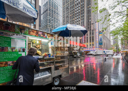 La città di New York bagel stand in una piovosa mattinata vicino al Radio City Music Hall il 6 Ave. Foto Stock