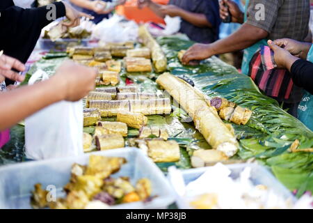 Persone che acquistano riso appiccicoso dessert in street market alimentare durante il digiuno del Ramadan al mese in Città di Banda Aceh, la provincia di Aceh, Indonesia Foto Stock