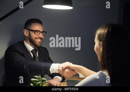 Maschio felice mano di scuotimento del lavoro femminile ricorrente durante il colloquio Foto Stock