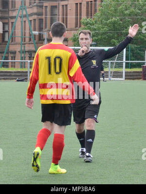 GLASGOW, SCOZIA - 8 giugno 2014: un arbitro soffia il suo fischio mentre un giocatore guarda a. Foto Stock