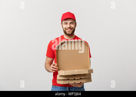 Consegna pizza concept. Ragazzo giovane è in grado di fornire e che mostra finestre di pizza in scatole. Isolato su sfondo bianco Foto Stock